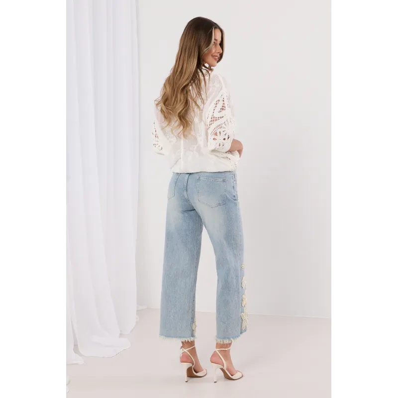 Jeansy z postrzępiona nogawką i biżuteryjnym zdobieniem