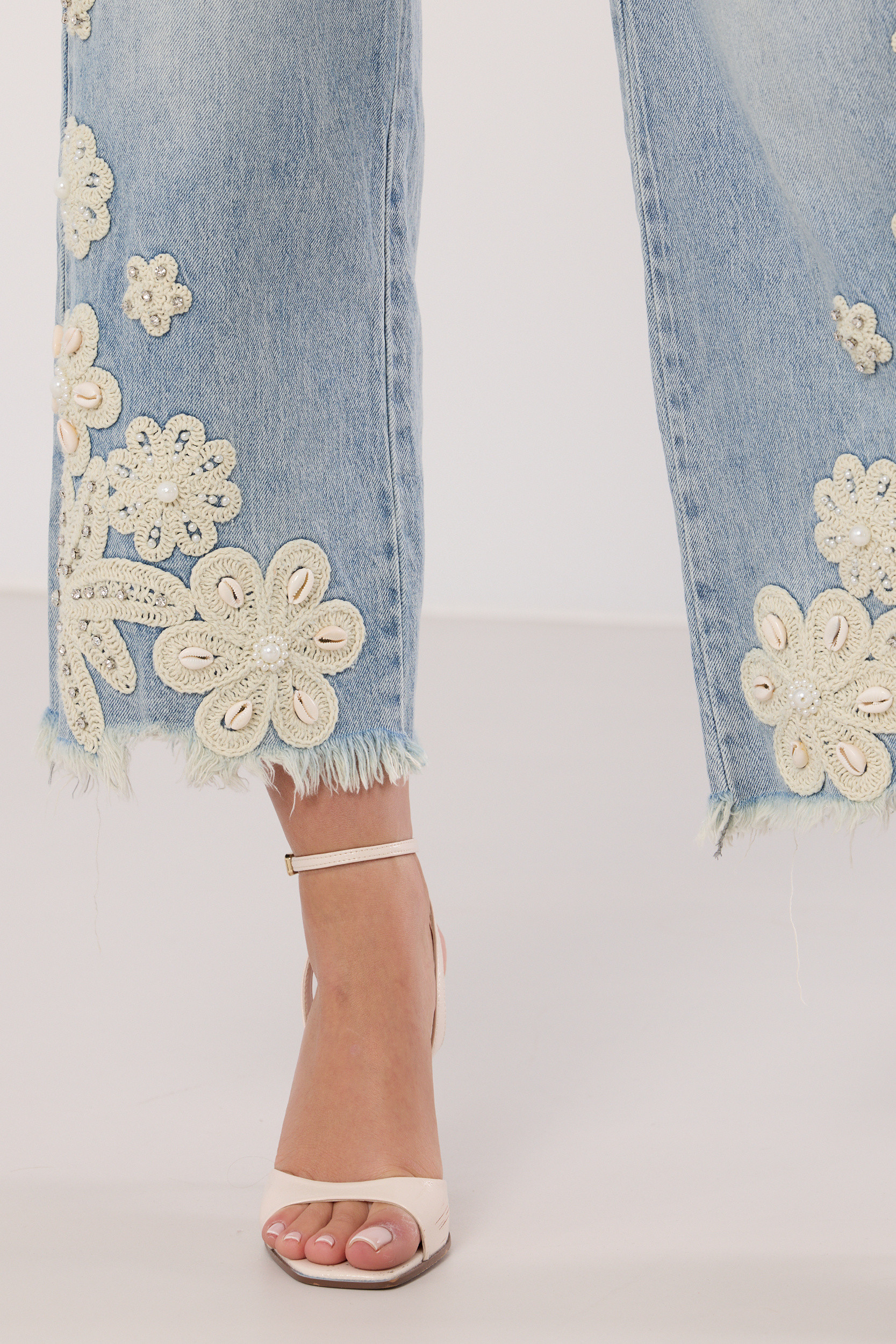 Jeansy z postrzępiona nogawką i biżuteryjnym zdobieniem