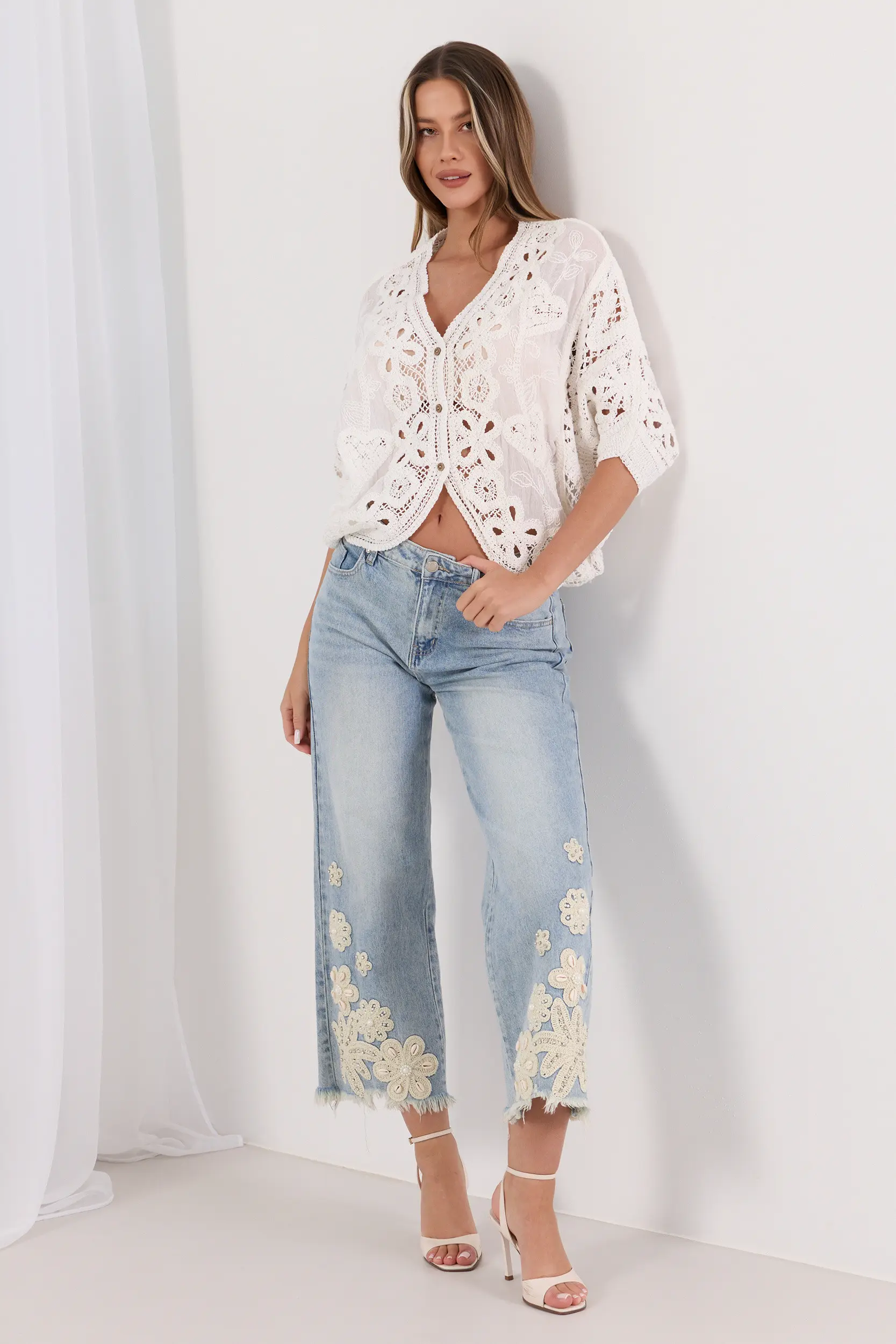 Jeansy z postrzępiona nogawką i biżuteryjnym zdobieniem