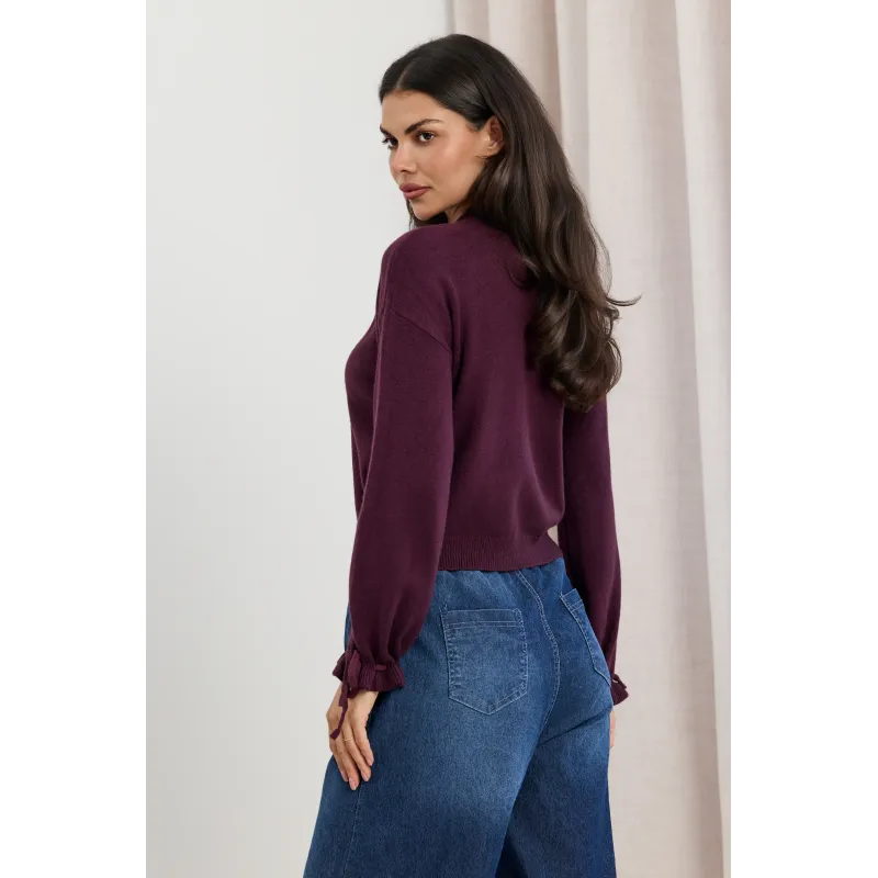 Dzianinowy sweter z kokardkami na rękawach